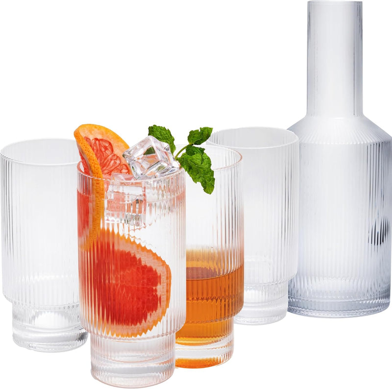 a group of glasses with orange slices and ice cubes