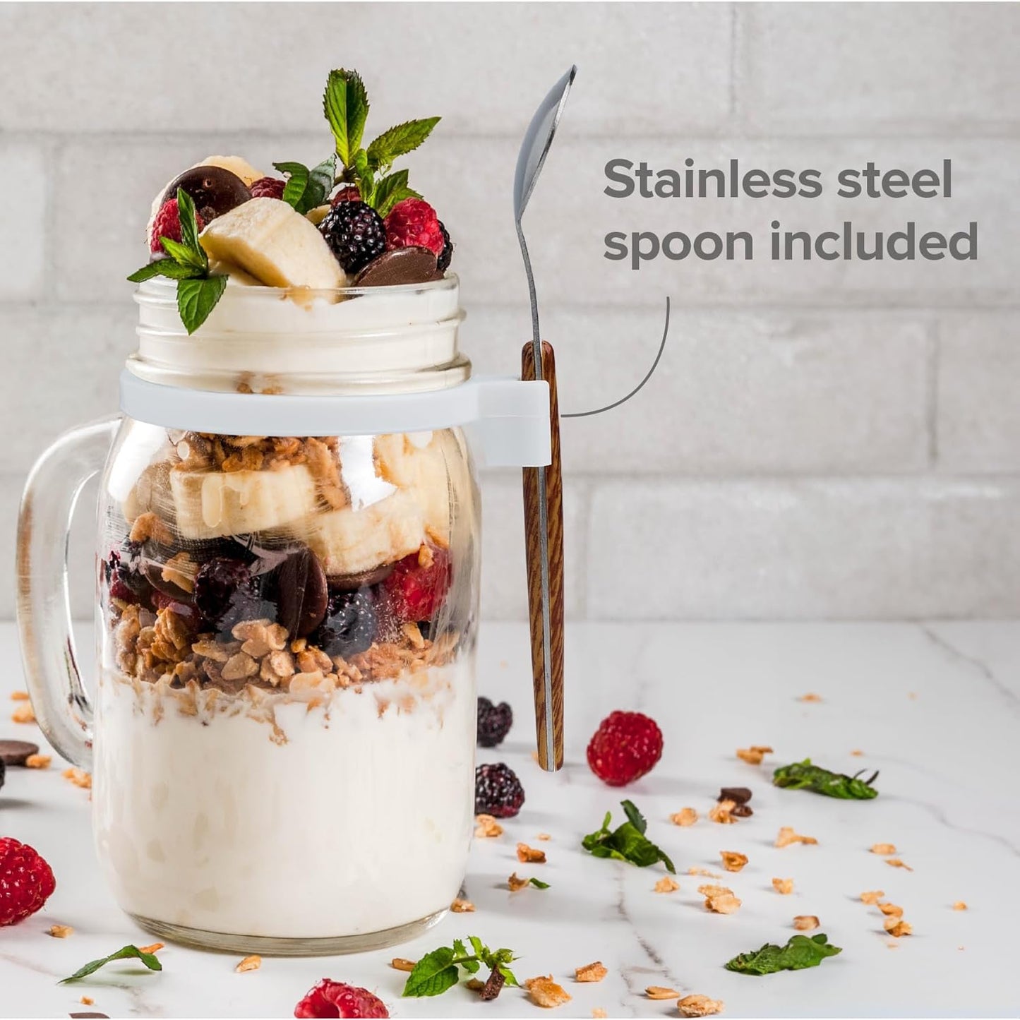 a jar of yogurt with fruit and berries with text: 'Stainless steel spoon included'