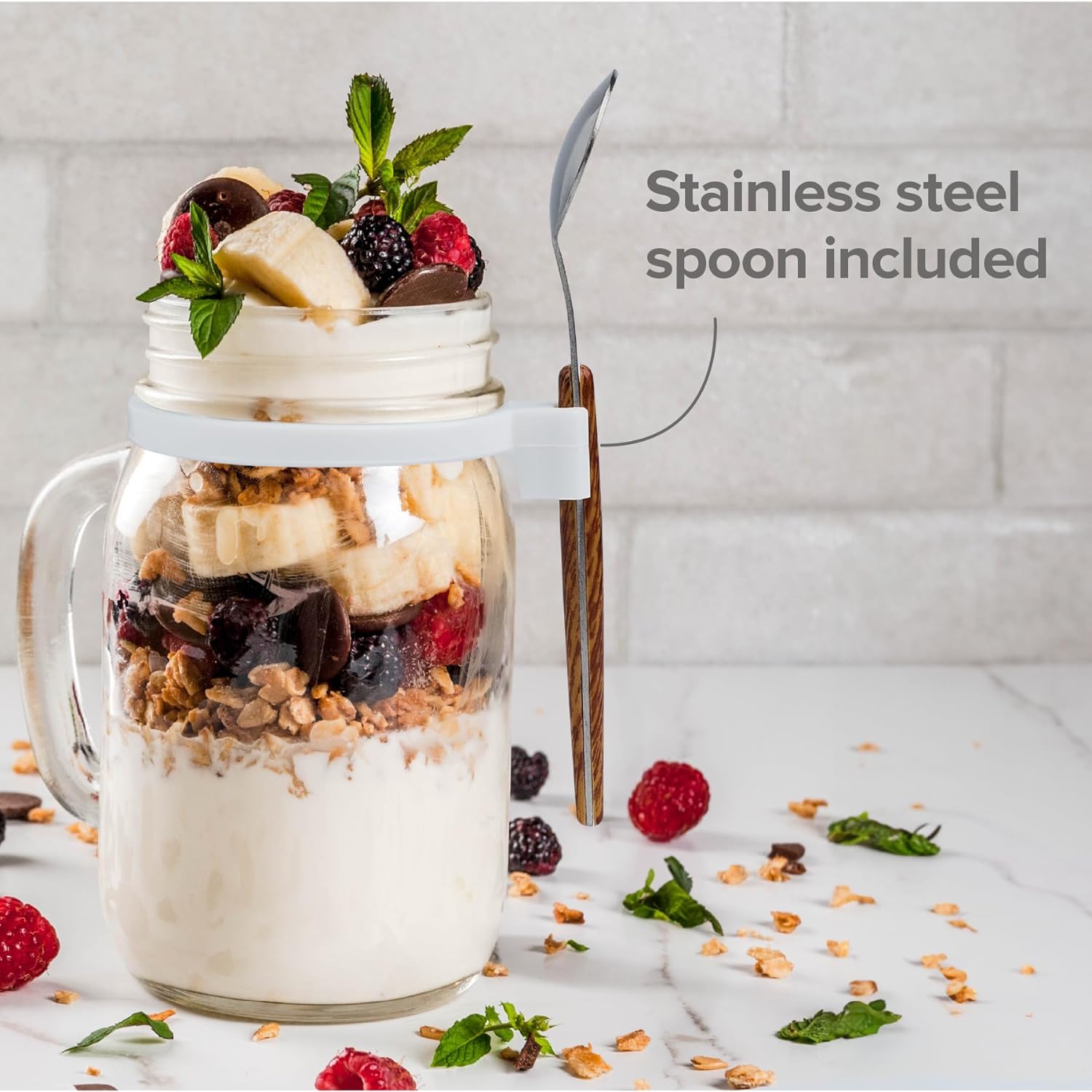 a jar of yogurt with fruit and berries with text: 'Stainless steel spoon included'